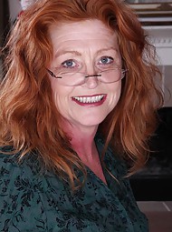 Older redhead Veronica Smith strips naked on the desk.